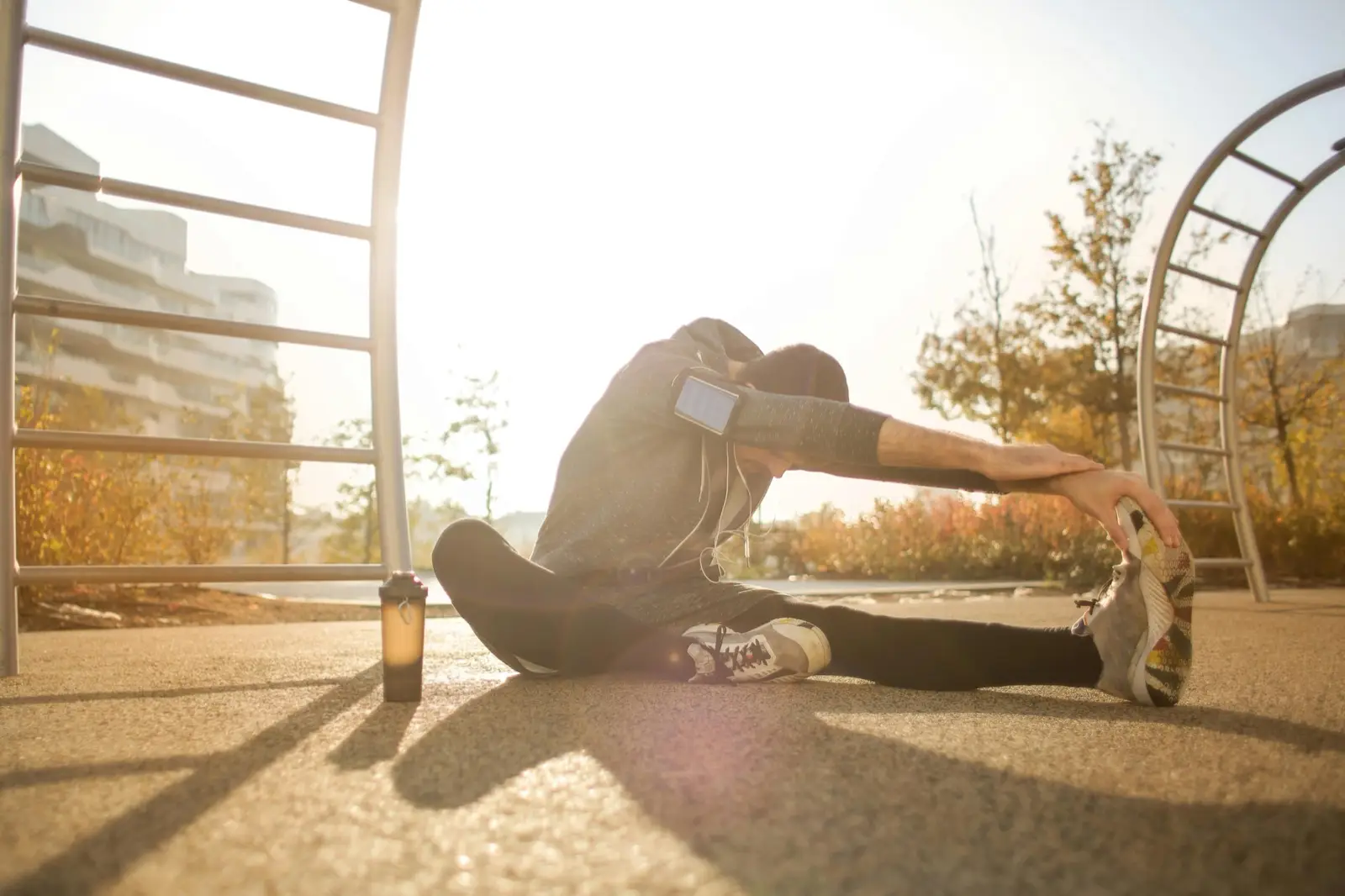 Sportif s’étirant en plein air au coucher de soleil, récupération après l’effort